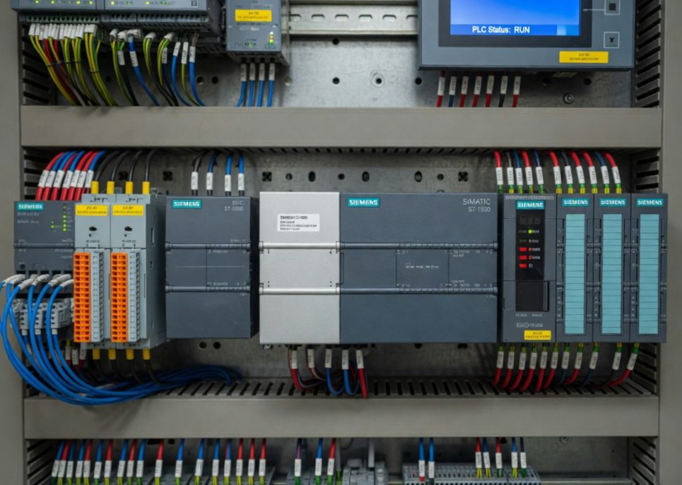 Two open control cabinets wired with an Allen-Bradley PLC and pushbutton panels.